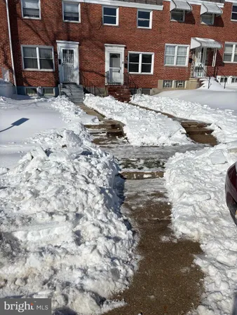a front view of a building with a yard covered with snow