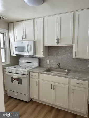 a kitchen with stainless steel appliances granite countertop white cabinets stove a sink and dishwasher