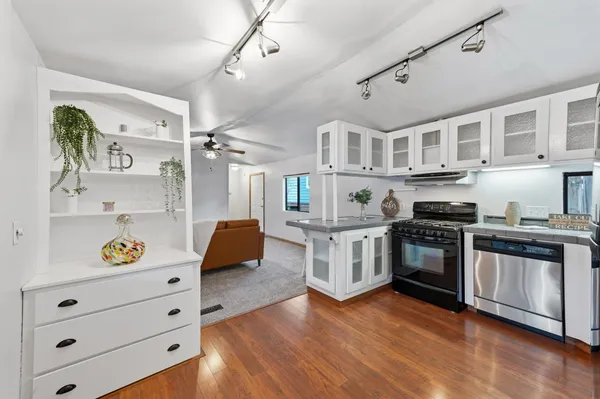 a kitchen with stainless steel appliances granite countertop a stove and cabinets