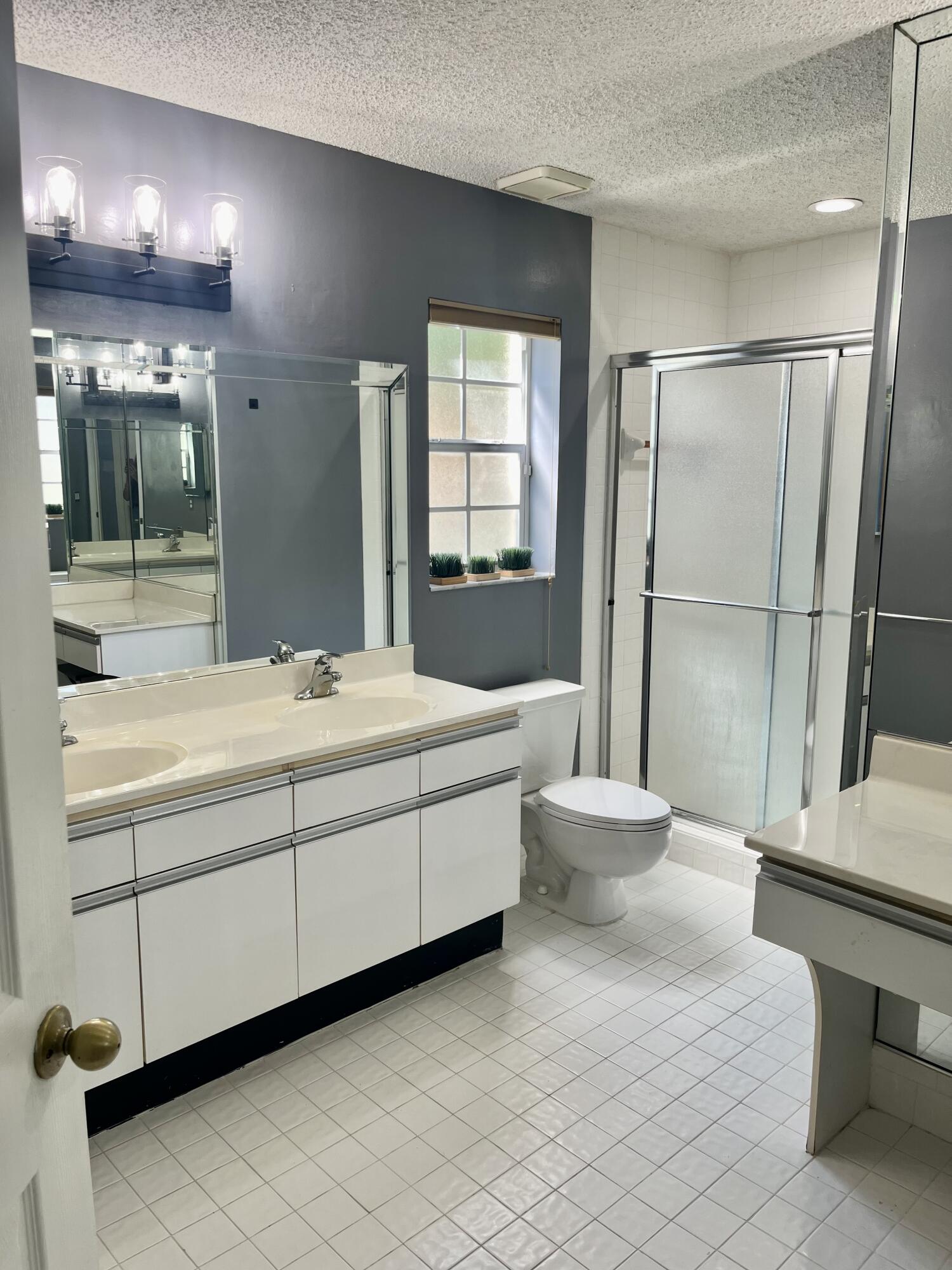 17262 Boca Club Boulevard, Unit 2407 Boca Raton, FL 33487 - Photo 15 of 25 a bathroom with a double vanity sink toilet and a mirror