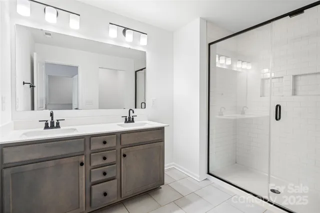 a bathroom with a double vanity sink mirror and shower