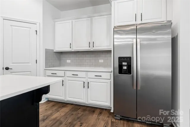 a kitchen with stainless steel appliances cabinets and a wooden floor