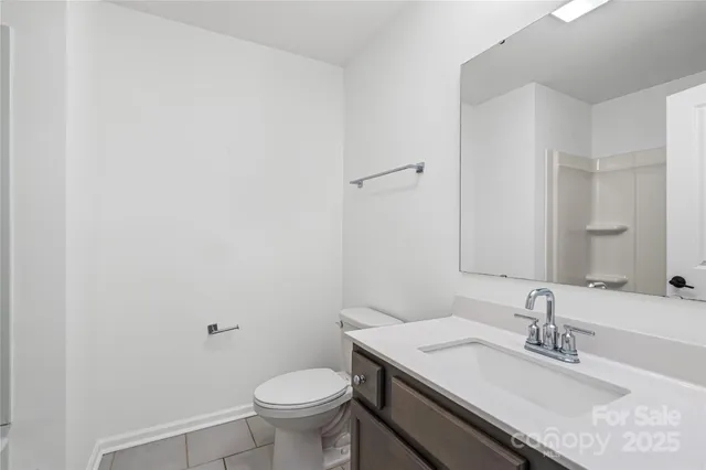 a bathroom with a granite countertop sink a toilet and a mirror