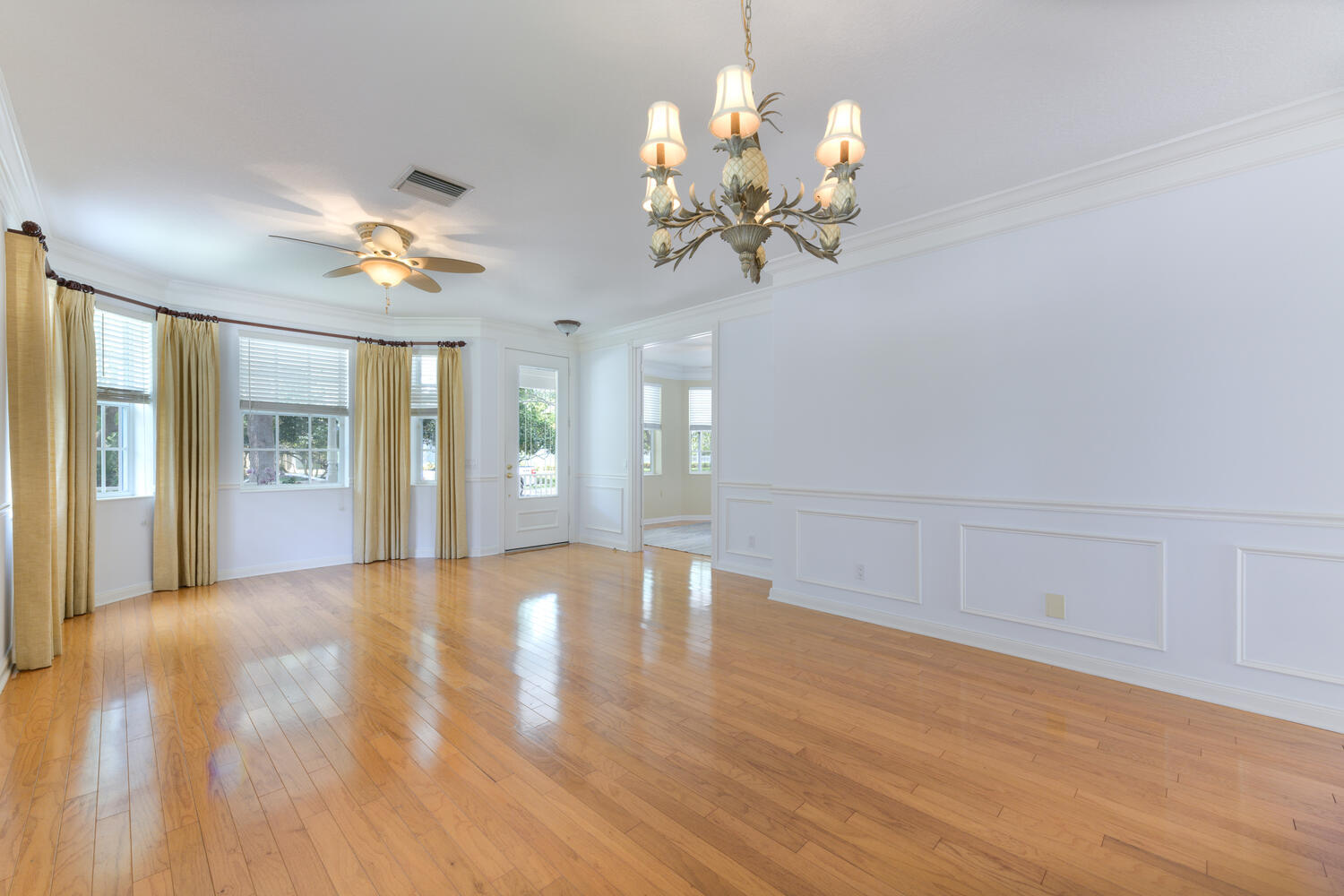 244 Barbados Drive Jupiter, FL 33458 - Photo 11 of 51 a view of an empty room with chandelier and wooden floor