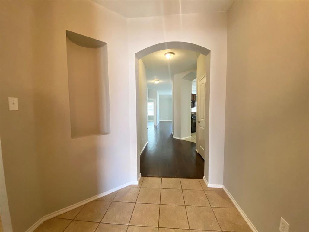 9717 Mystic Dunes Drive McKinney, TX 75072 - Photo 2 of 16 a view of a hallway with wooden floor and a bathroom