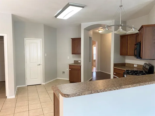 a kitchen with stainless steel appliances granite countertop a sink a refrigerator and a granite counter tops