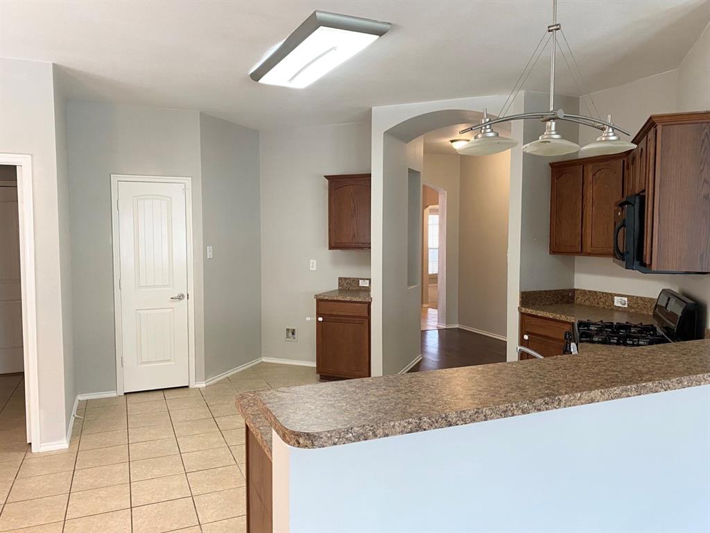 9717 Mystic Dunes Drive McKinney, TX 75072 - Photo 4 of 16 a kitchen with stainless steel appliances granite countertop a sink a refrigerator and a granite counter tops