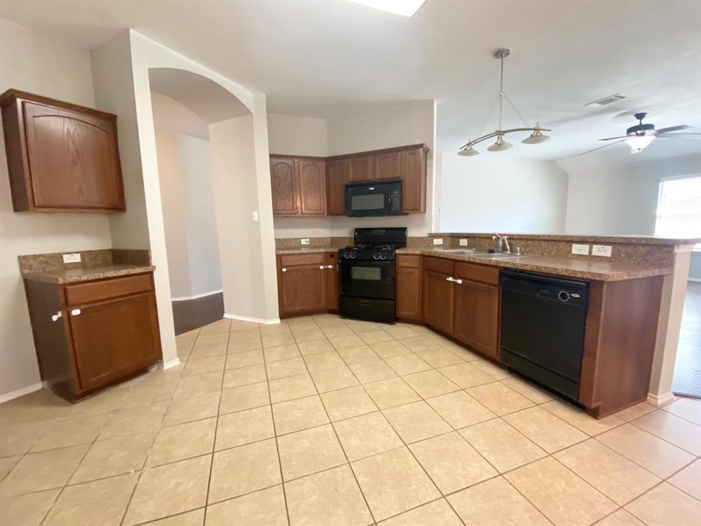 9717 Mystic Dunes Drive McKinney, TX 75072 - Photo 6 of 16 a kitchen with stainless steel appliances granite countertop a stove a sink and a refrigerator