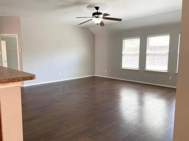 a view of a livingroom with wooden floor and a ceiling fan