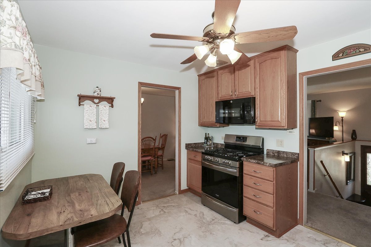 1335 Gentry Road Hoffman Estates, IL 60169 - Photo 13 of 33 a kitchen with stainless steel appliances granite countertop a stove top oven a sink a dining table and chairs