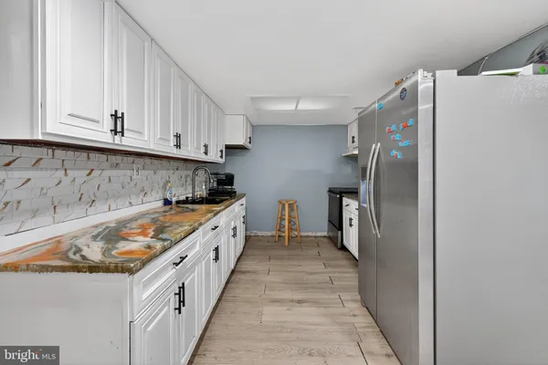 a kitchen with granite countertop a refrigerator and a sink