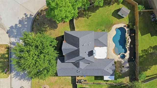 an aerial view of a house with a yard and a large tree