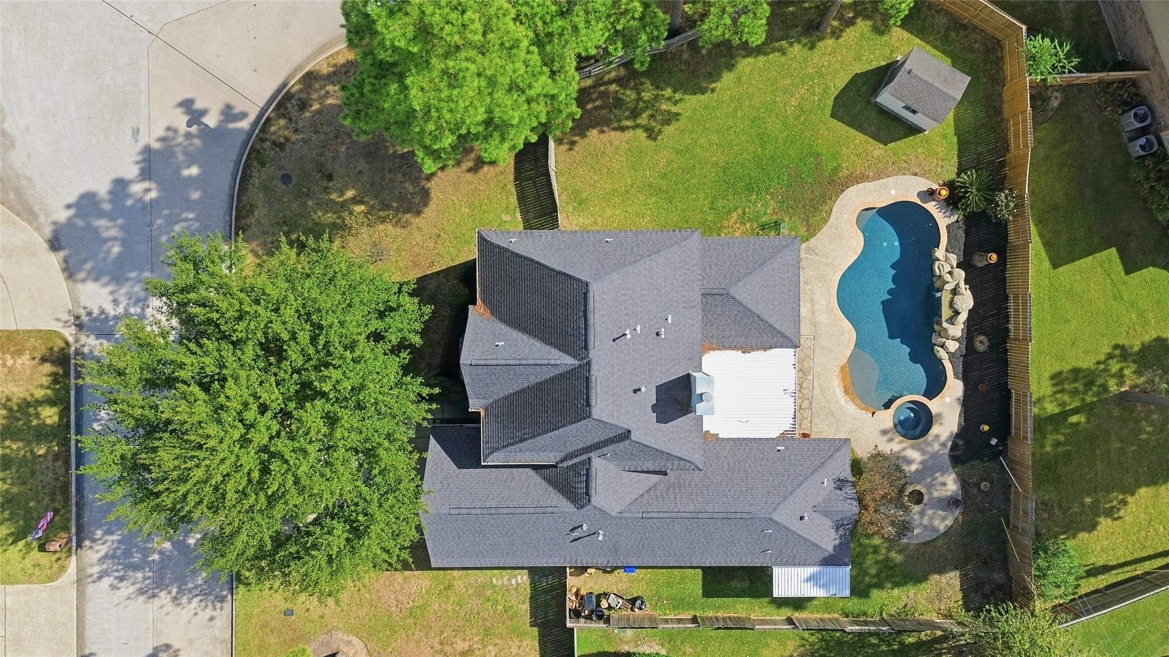 an aerial view of a house with a yard and a large tree