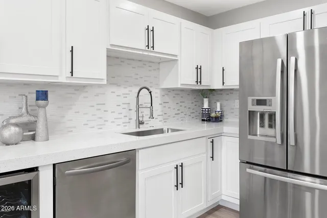 a kitchen with stainless steel appliances a sink stove refrigerator and cabinets