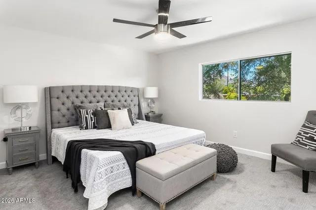 a bedroom with a bed a couch and a window