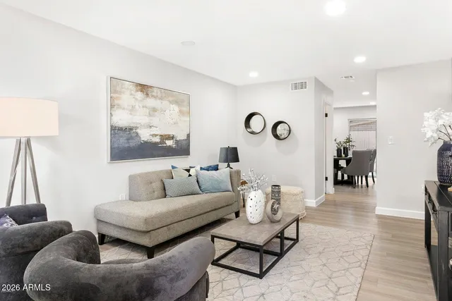a living room with furniture and a wooden floor