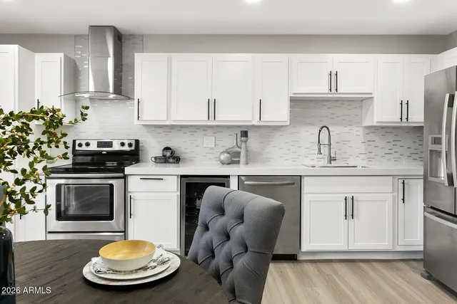 a kitchen with stainless steel appliances granite countertop a sink a stove cabinets and wooden floor