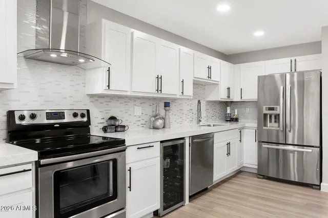 a kitchen with stainless steel appliances granite countertop a stove a sink and a refrigerator