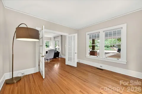 a view of empty room with wooden floor and fan