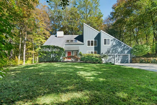 a front view of a house with a yard and trees