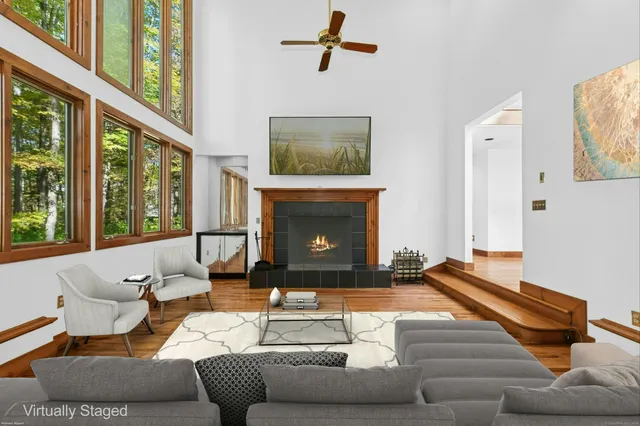 a living room with furniture fireplace and a large window