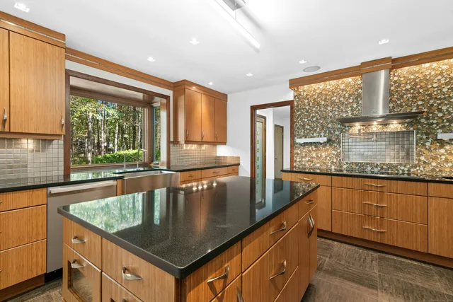a kitchen with stainless steel appliances granite countertop a sink a stove and a wooden cabinets