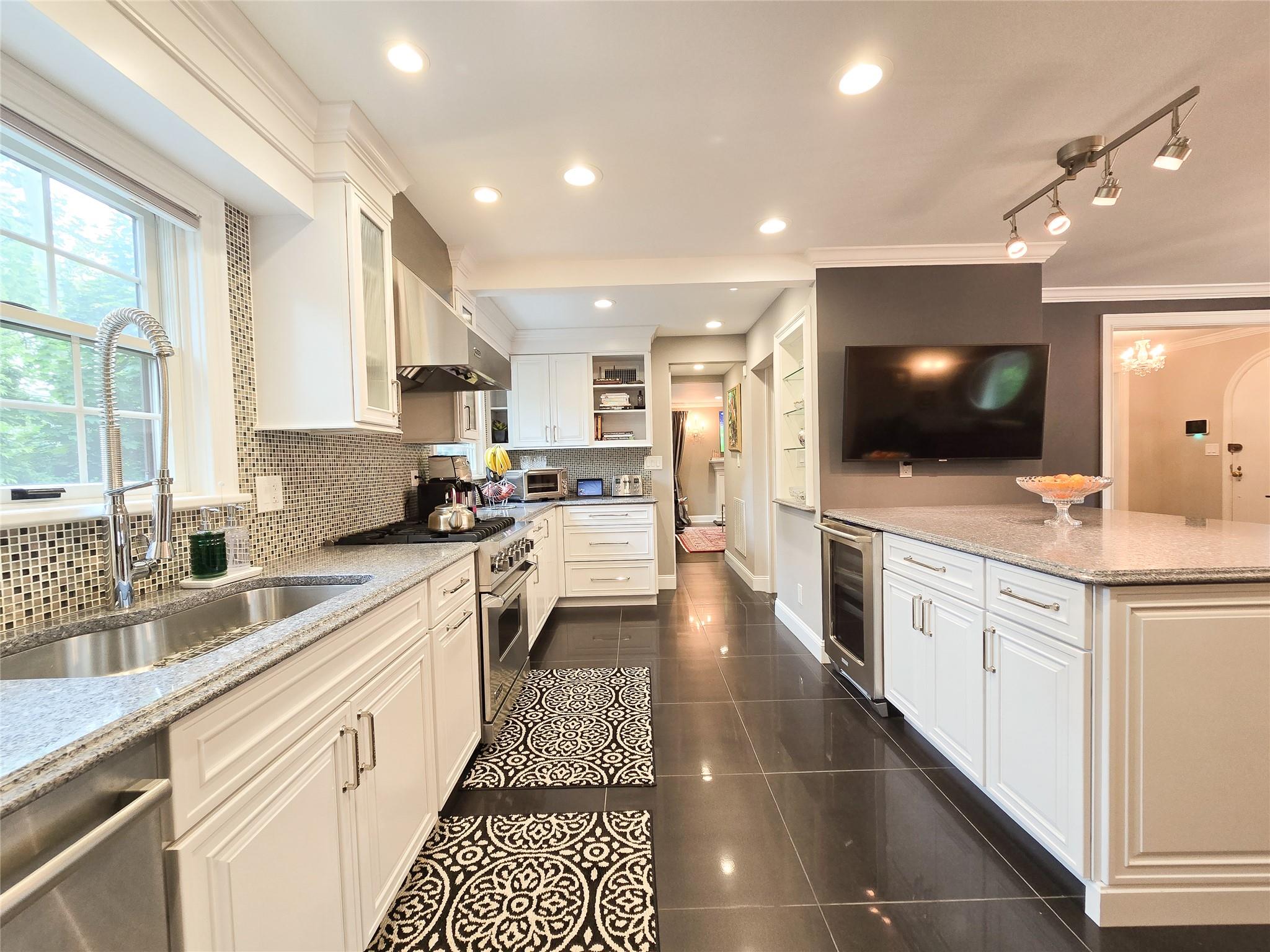 a large kitchen with stainless steel appliances lots of counter space and a sink