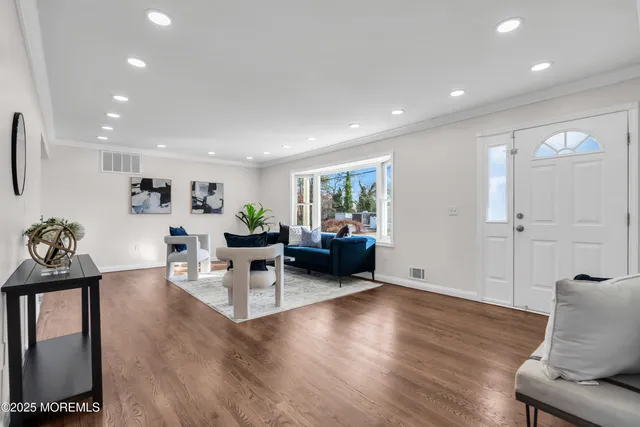 a living room with furniture and a wooden floor