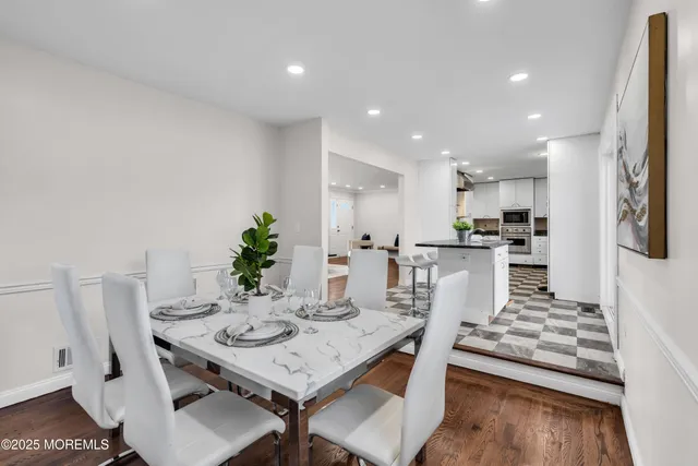 a living room with kitchen island furniture and a dining table with kitchen view