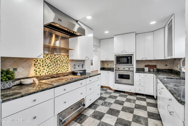 a kitchen with granite countertop appliances cabinets and a sink