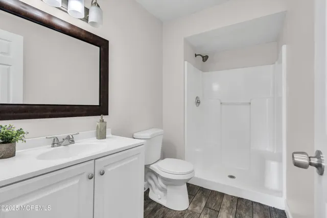 a bathroom with a sink a toilet and shower