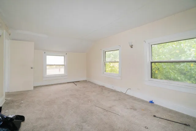 a view of a hallway with wooden floor and windows