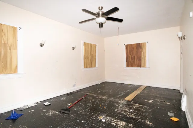 a view of a bedroom with a ceiling fan and a window