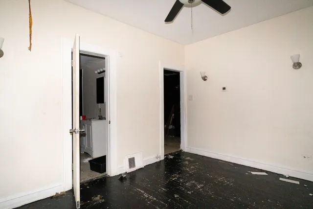 an empty room with a ceiling fan and carpet