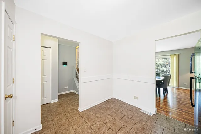 a view of a hallway with wooden floor and dining room