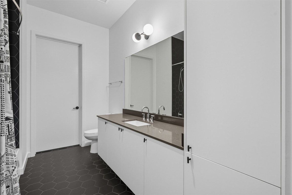 800 Embassy Drive, Unit 320 Austin, TX 78702 - Photo 11 of 23 a bathroom with a granite countertop sink and a mirror
