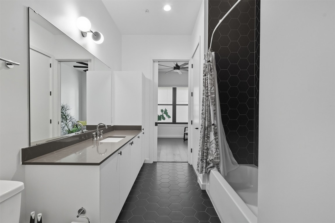 800 Embassy Drive, Unit 320 Austin, TX 78702 - Photo 12 of 23 a bathroom with a sink and mirror with bathtub