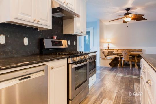 823 North Fairview Street Ridgecrest, CA 93555 - Photo 9 of 35 a kitchen with stainless steel appliances granite countertop a stove top oven a sink dishwasher a dining table and chairs with wooden floor