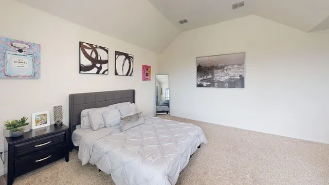 a bedroom with a bed and painting on the wall