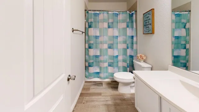 a bedroom with a bed and a flat tv screen on dresser