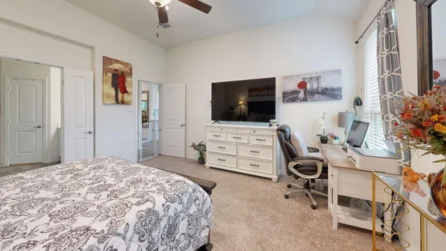 a bedroom with a bed a large window and furniture