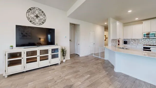 a large white kitchen with a large window and stainless steel appliances
