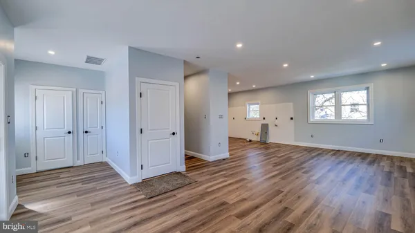 a view of empty room with wooden floor and window