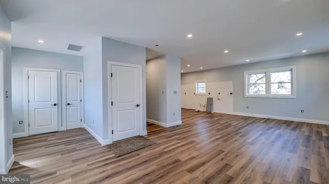 a view of empty room with wooden floor and window