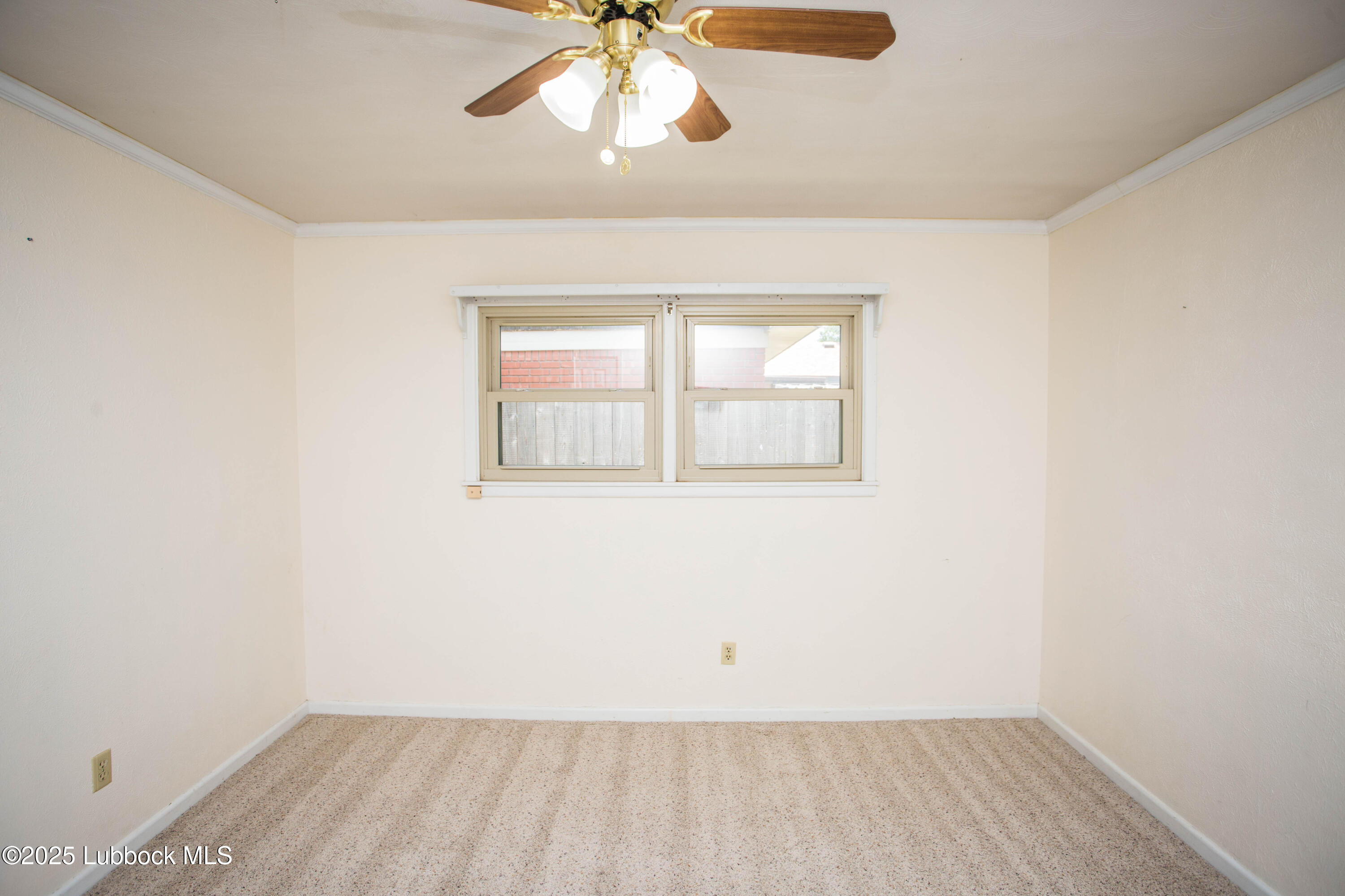 5424 31st Street Lubbock, TX 79407 - Photo 28 of 45 an empty room with a chandelier fan and windows