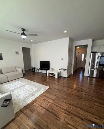 a living room with furniture and a wooden floor