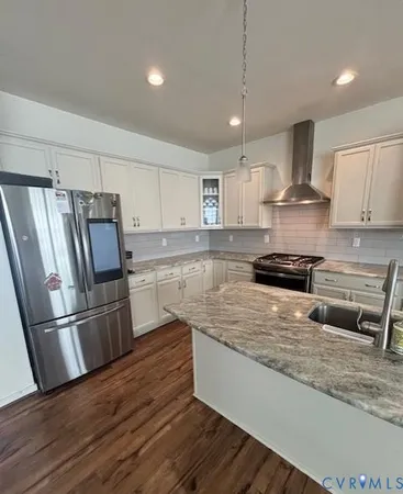 a kitchen with stainless steel appliances granite countertop a refrigerator a stove a sink and a oven