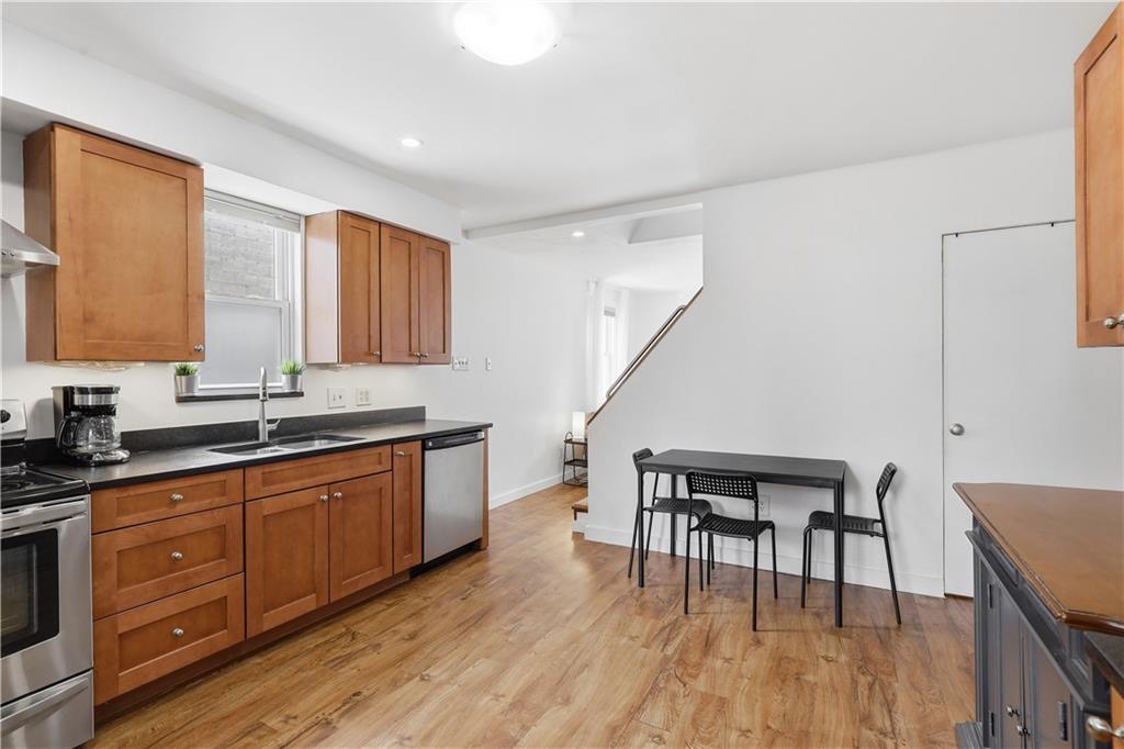 187 42nd Street Pittsburgh, PA 15201 - Photo 8 of 26 a large kitchen with wooden floors and wooden cabinets
