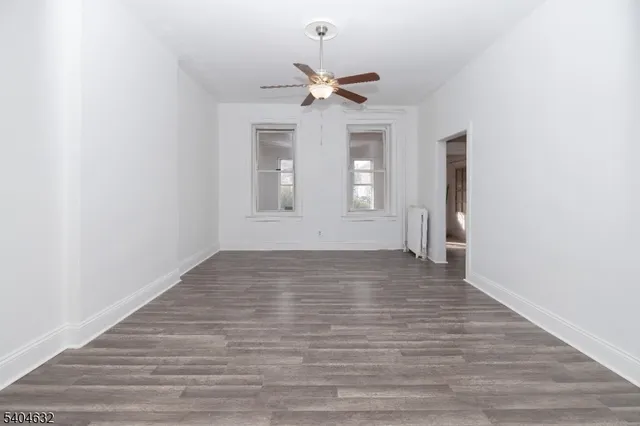 a kitchen with stainless steel appliances white cabinets and wooden floor