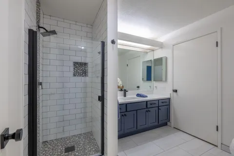 a bathroom with a double vanity sink a toilet and mirror